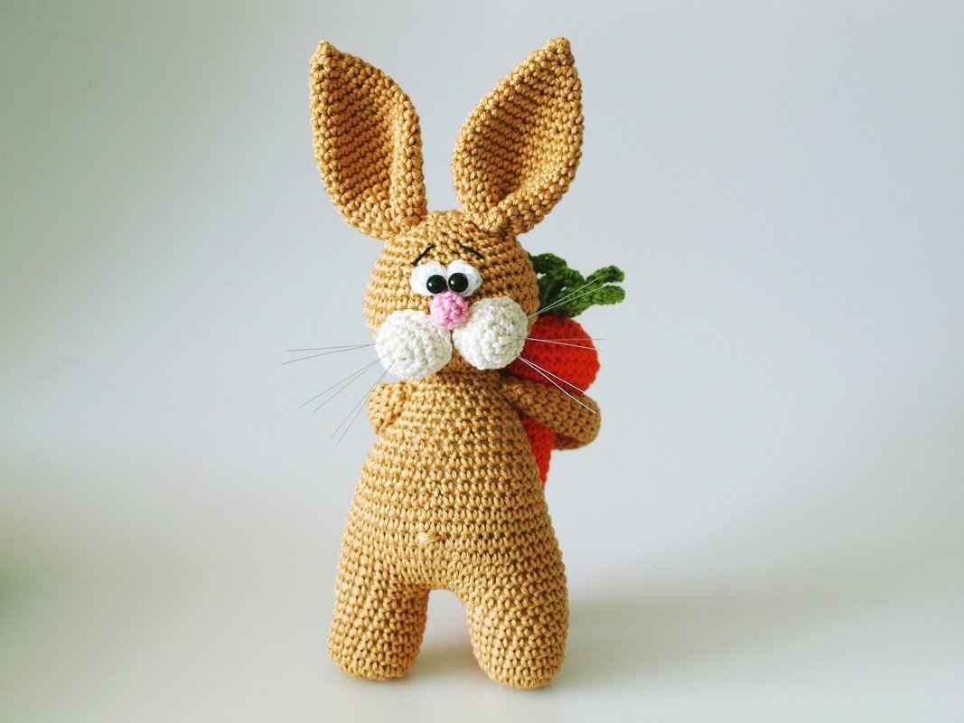 Gehäkelter Amigurumi-Hase mit großen Ohren, rosa Nase und Karotte