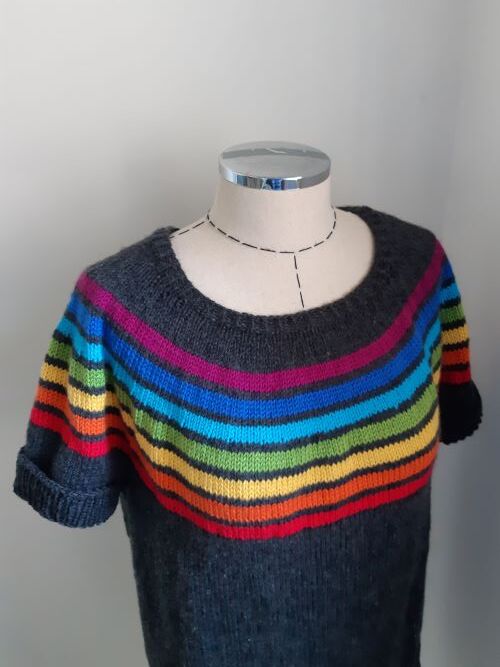 Dark grey women's short-sleeve knitted sweater with multicolored horizontal stripes on the round yoke, shown on a mannequin.