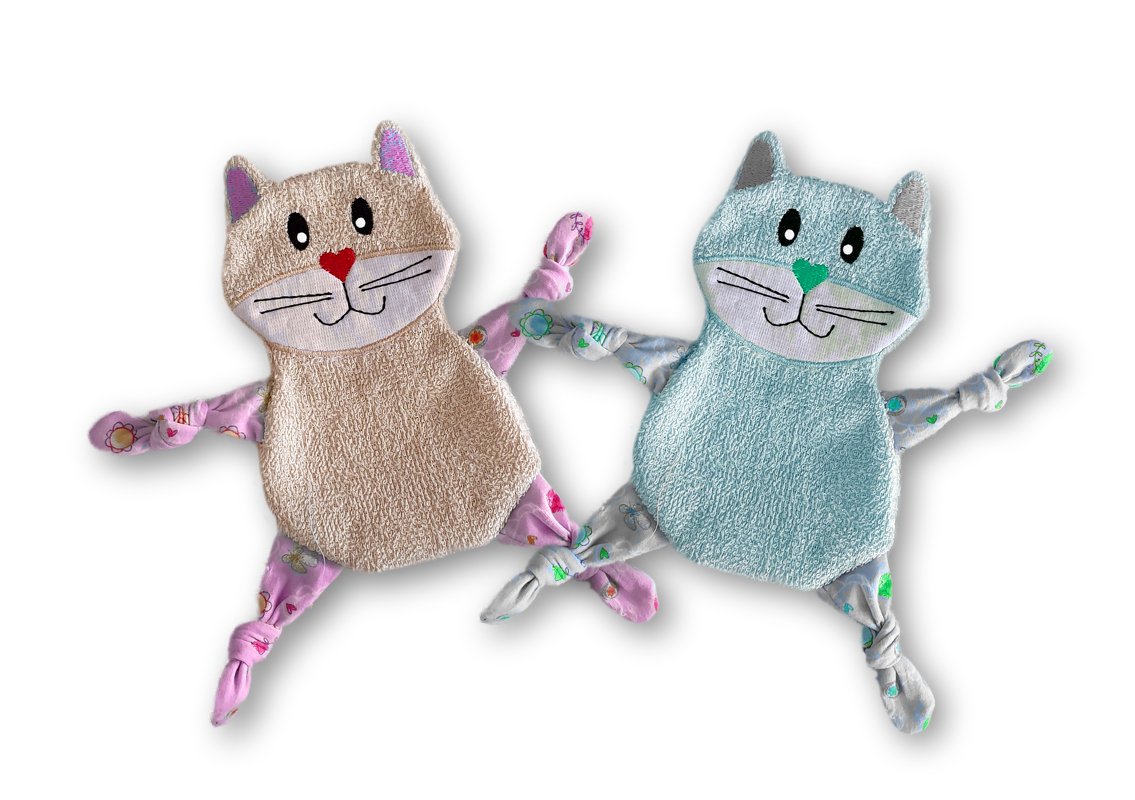 Zwei gestickte Katzen‑Schmusetücher in Beige und Hellblau mit aufgestickten Gesichtern und verknoteten Armen und Beinen.