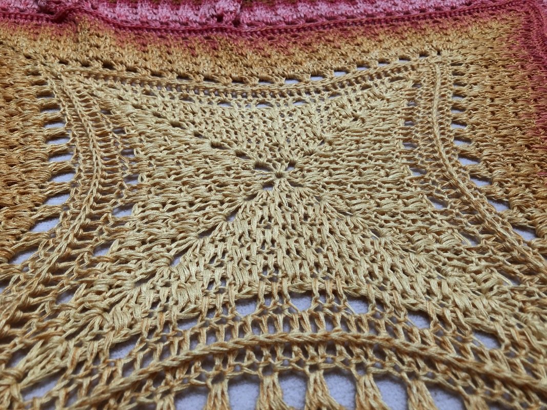 Gehäkelte Babydecke mit quadratischem Spitzenmotiv und Gelb‑Rosa‑Farbverlauf