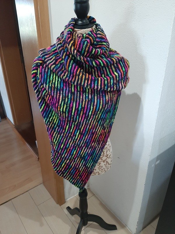 Asymmetrisches Dreieckstuch mit neonfarbenen Streifen und dunklen Kontrastreihen auf einer Schneiderpuppe