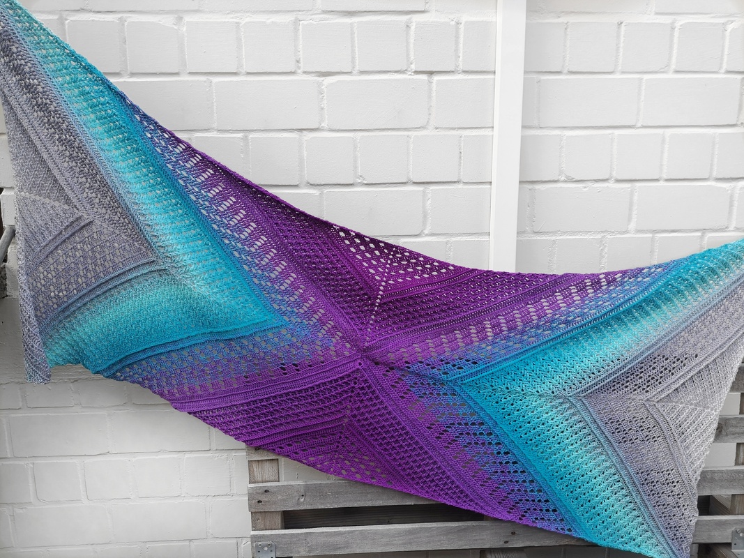 Gehäkeltes Tuch mit Farbverlauf in Grau, Türkis und Lila sowie filigranen Lochmustern