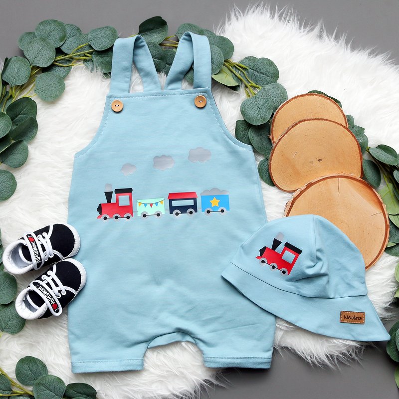 Hellblauer Baby-Strampler und Mütze mit buntem Zugmotiv und Wolken als Plottdatei.