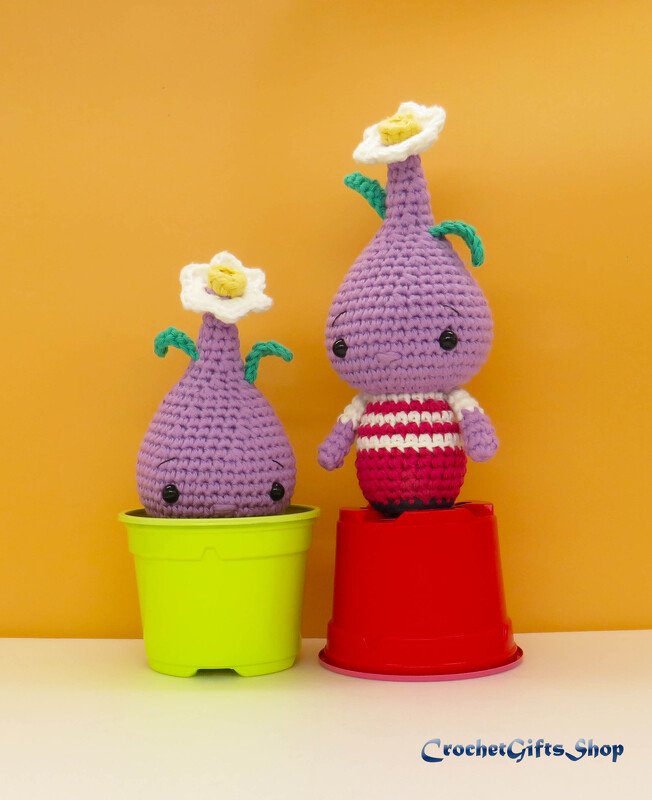 Two purple crocheted amigurumi plant dolls with white flowers on top, one in a green pot and one in a red pot