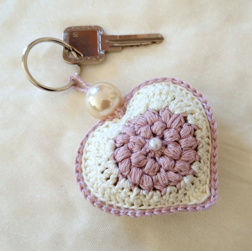 Cremeweißes und zartrosa gehäkeltes Herz mit Blumenmotiv, Perle und Schlüsselring