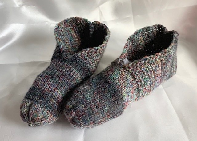 Zwei unisex gestrickte Pantoffeln in mehrfarbiger Melange, Vorder- und Seitenansicht