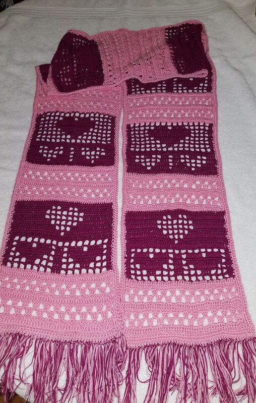 Crochet scarf with repeated heart and textured panels in two pinks and fringe
