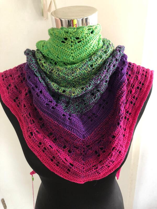 Gehäkeltes Dreieckstuch mit Farbverlauf Pink–Lila–Grün auf schwarzer Schneiderpuppe, durchbrochenes Lochmuster