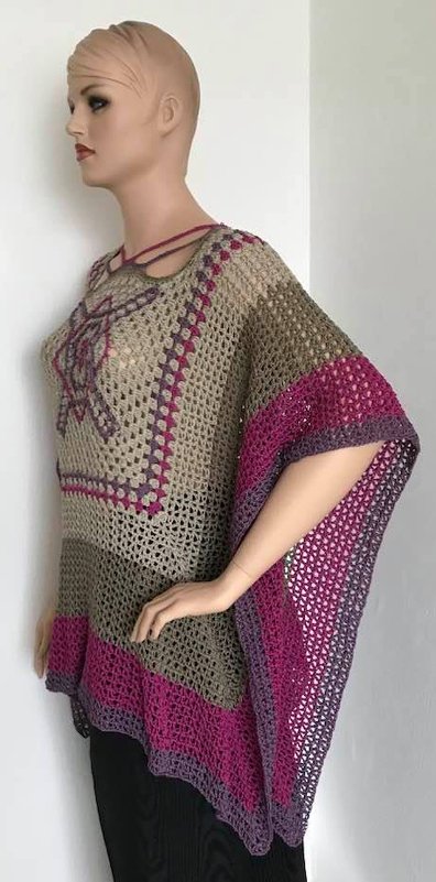 Mannequin trägt beige Häkeltunika mit quadratischem Einsatz und pink-violetten Streifen