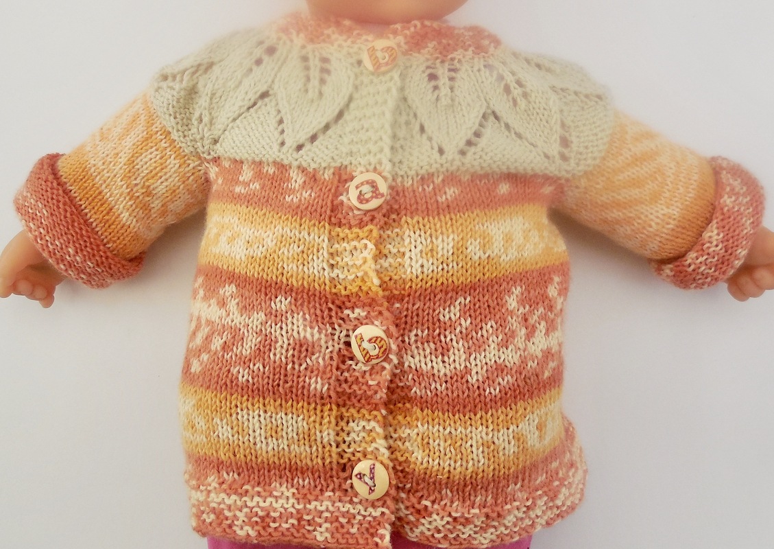 Gestrickte Babyjacke in Orange, Gelb und Creme mit Lochmusterpasse und herzförmigen Knöpfen