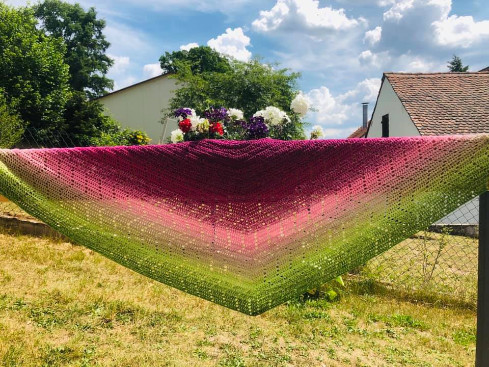 Gehäkeltes Dreieckstuch mit Farbverlauf von Pink zu Grün, aufgehängt