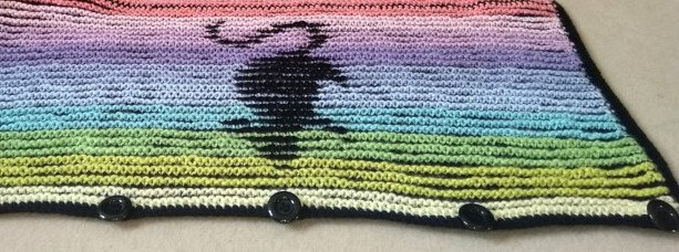 Gestrickter Bund mit Pastellverlauf, schwarzer Katzen-Silhouette und vier schwarzen Knöpfen