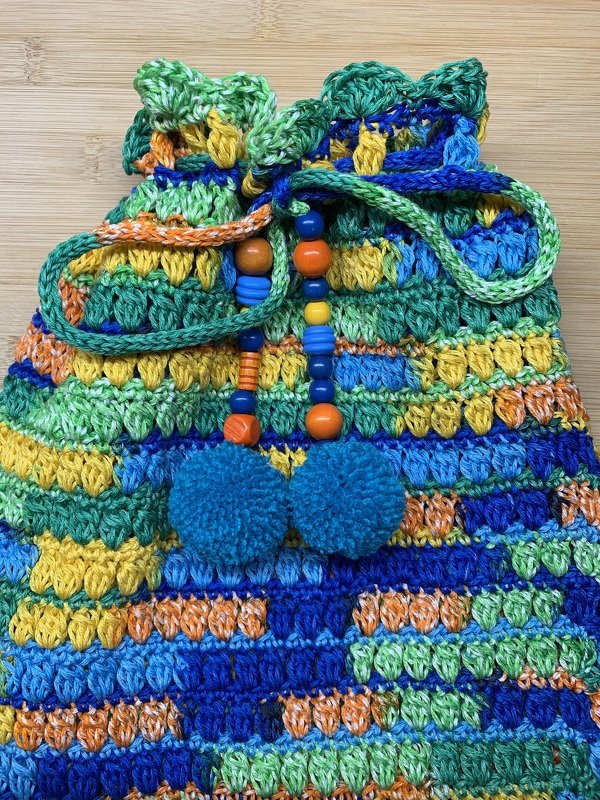 Gehäkelter blau-grün-gelber Rucksackbeutel mit Kordelzug, Perlen und zwei blauen Bommeln