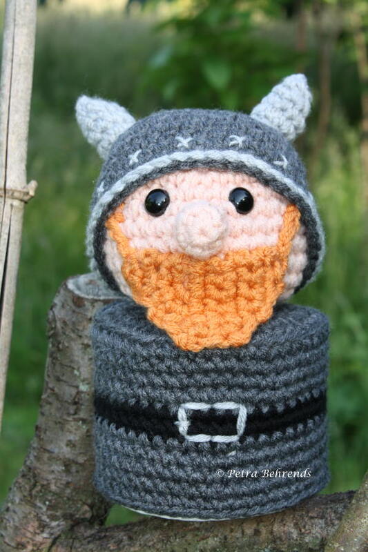 Gehäkelter Zwerg mit Wikingerhelm und orangefarbenem Bart auf Baumstumpf