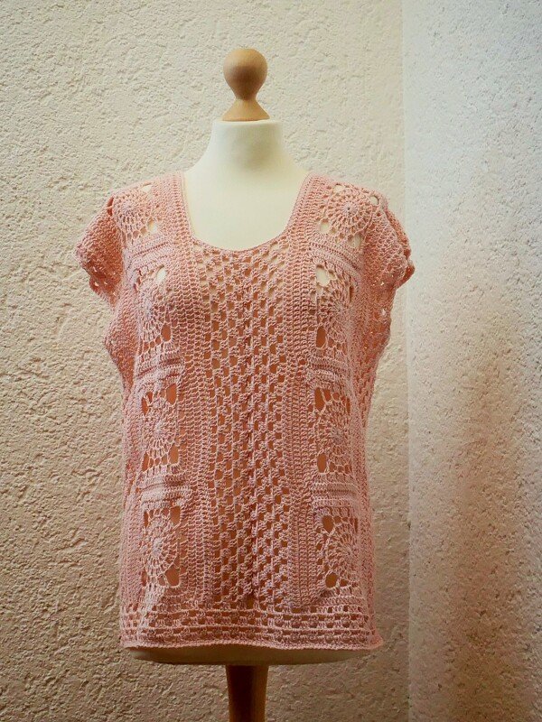 Lachsrosa gehäkeltes Damen-Top mit weitem Rundhalsausschnitt, kurzen Ärmeln und feinem Lochmuster auf einer Schneiderpuppe