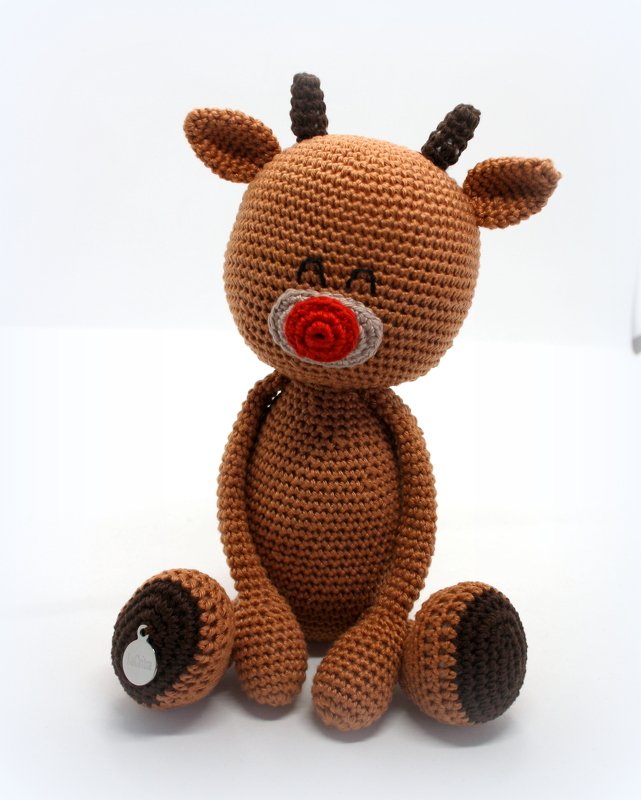 Nahaufnahme eines gehäkelten braunen Amigurumi-Rentiers mit roter Nase und dunklen Hufen vor hellem Hintergrund