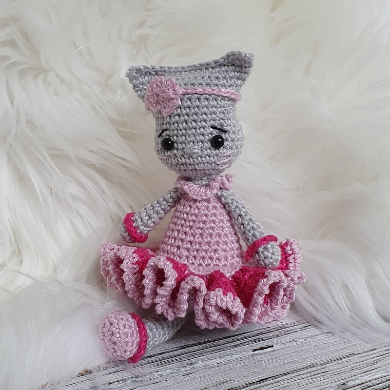 Gehäkelte Amigurumi-Katze in Grau mit rosa Kleid, Rüschenrock, Stirnband und Blüte