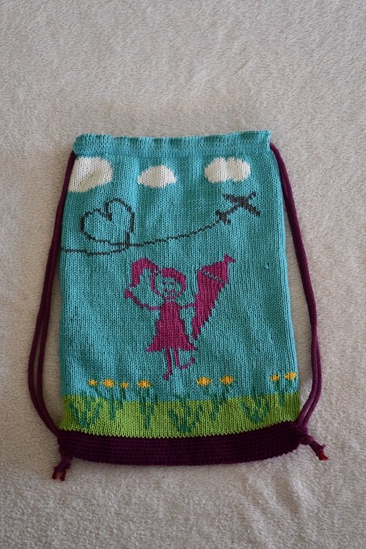 Gestrickter türkiser Kordelbeutel mit Mädchenmotiv, Schultüte, Wolken und Blumen