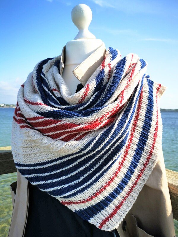 Maritimes gestricktes Dreieckstuch in Blau, Rot und Weiß lässig umgelegt auf einer Puppe