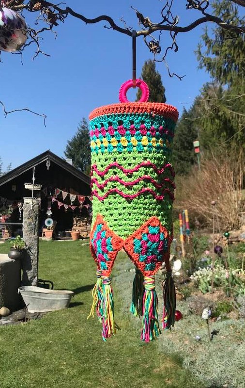 farbenfroher gehäkelter Lampion mit Fransen im Garten
