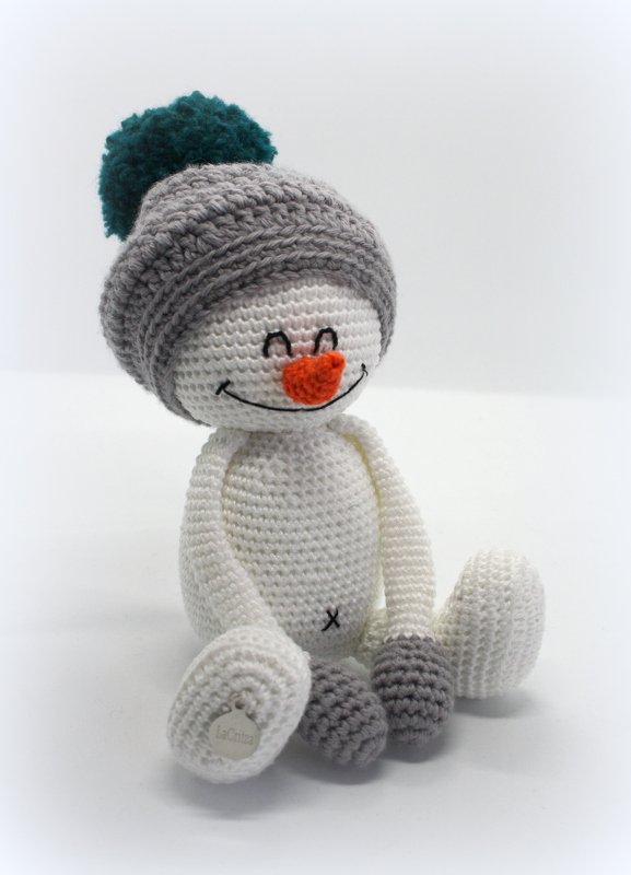 Gehäkelter Amigurumi-Schneemann mit grauer Bommelmütze und orangefarbener Nase