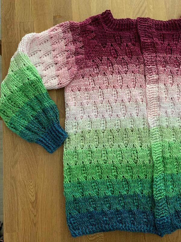 Nahaufnahme gehäkelte Damenjacke mit Reliefstichen, gerippten Bündchen und Farbverlauf von Dunkelrot zu Blau