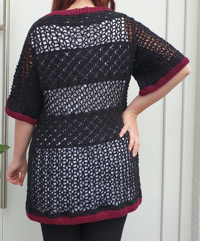 Schwarzer gehäkelter Damen-Pullover mit Lochmuster und bordeauxroten Bündchen, Rückenansicht.