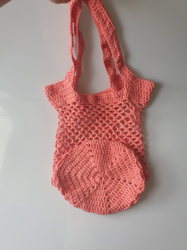 Coral crochet market bag with round base, mesh body and wide shoulder straps