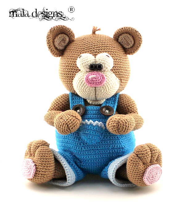 Gehäkelter brauner Teddybär mit weißer Schnauze, rosa Nase und blauer Latzhose