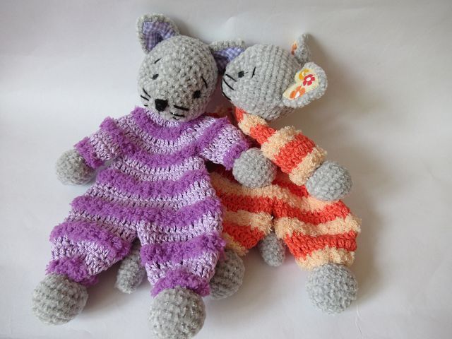 Zwei grau gehäkelte Amigurumi-Katzen mit gestreiften Overalls, bestickten Gesichtern und abgesetzten Ohren