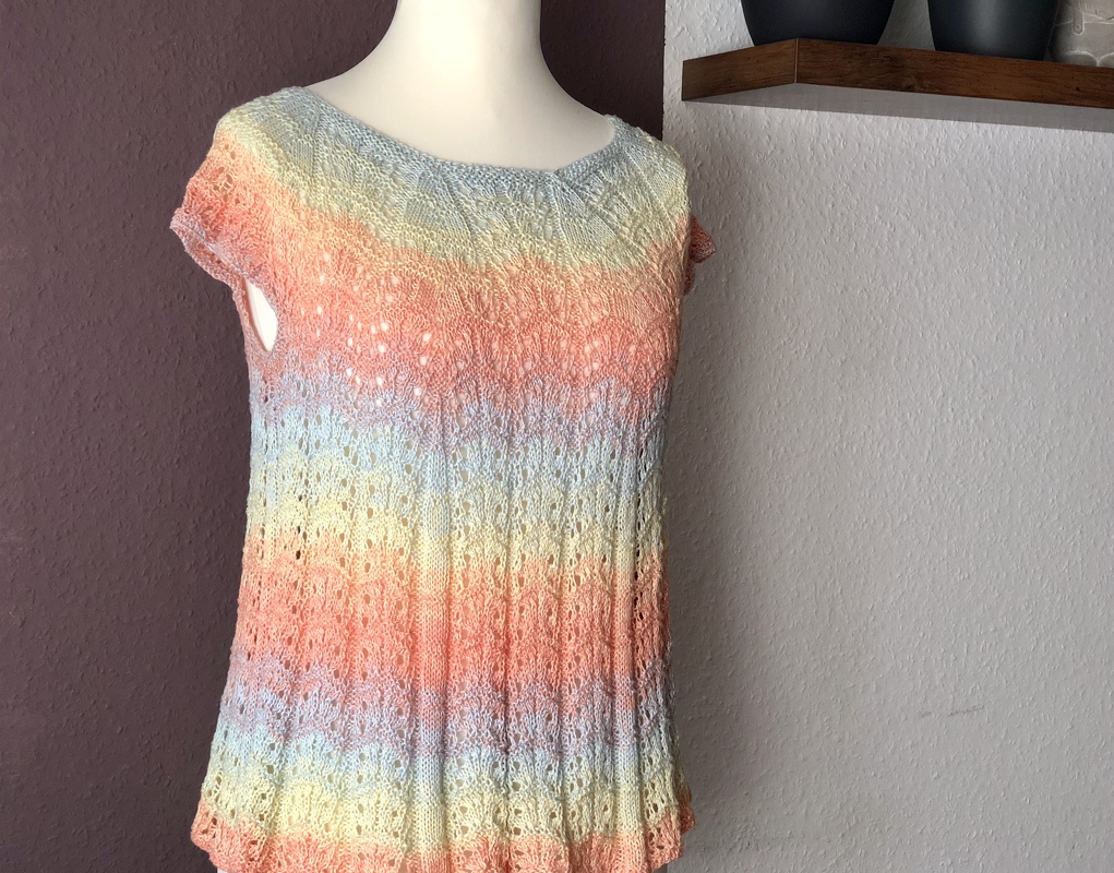 Gestrickte pastellfarbene Tunika mit Lochmuster auf Schaufensterpuppe