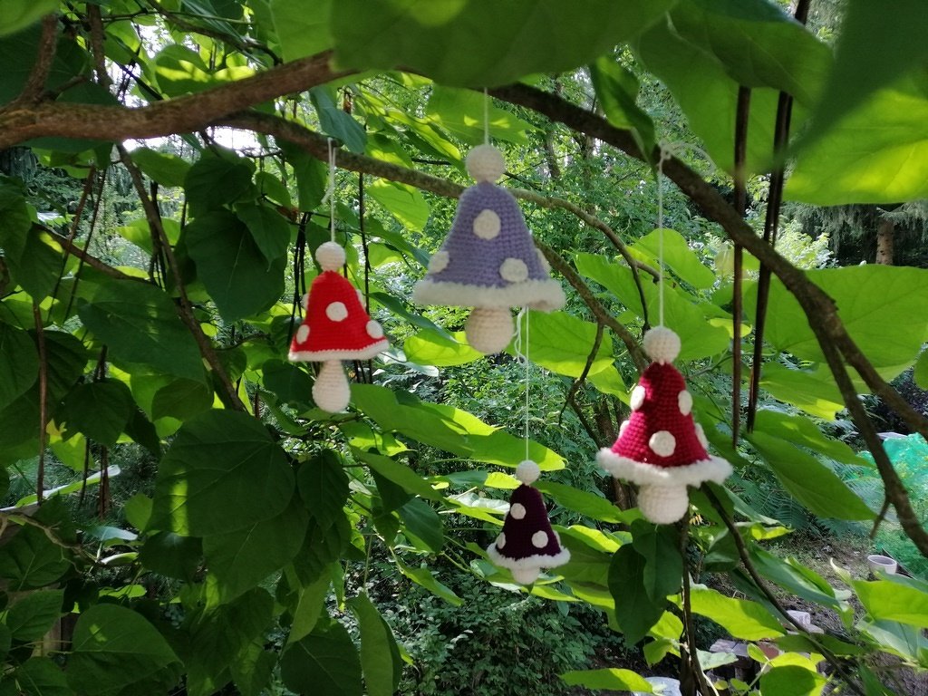 Kleine schnell gehäkelte Pilzanhänger in Rot, Dunkellila und Helllila mit weißen Punkten an Schnüren