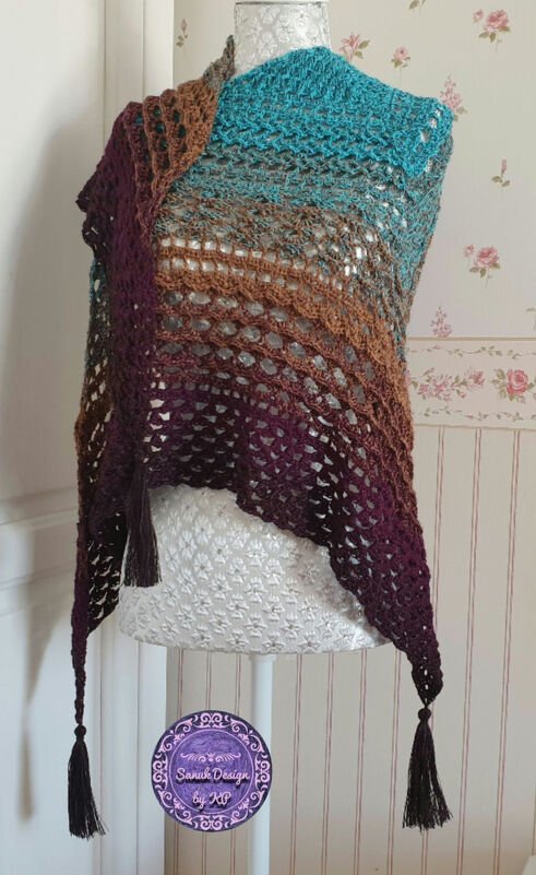 Gehäkeltes Dreieckstuch auf Schneiderpuppe, Farbverlauf Türkis–Braun–Violett, offenes Muster und Quasten.