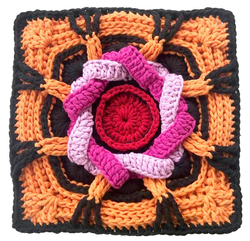Gehäkeltes Quadrat mit rotem Zentrum, pinken Zöpfen und orange‑schwarzem geflochtenem Rand