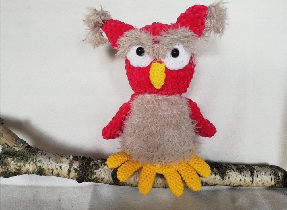 Amigurumi-Eule in Rot und Beige mit flauschigem Bauch, gelbem Schnabel und gehäkelten Krallen