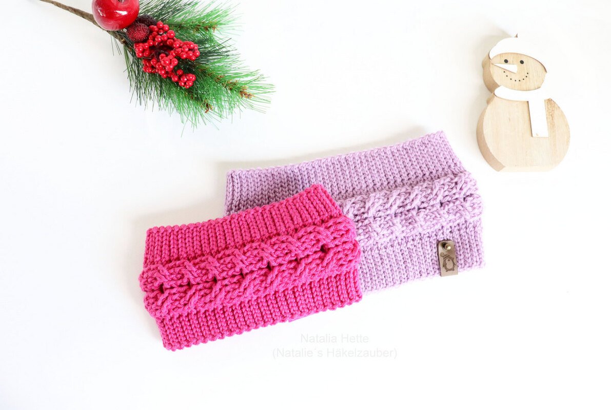 Pink and lavender cable-pattern crochet headbands with a pine sprig and wooden snowman on a white background.