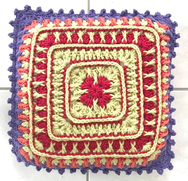 Granny-inspiriertes gehäkeltes Kissen mit Stäbchen- und Reliefmaschen