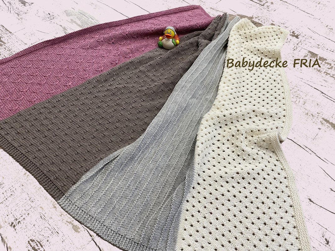 Ansicht einer gestrickten Babydecke mit Loch-, Rippen- und Strukturmustern in vier Farben.