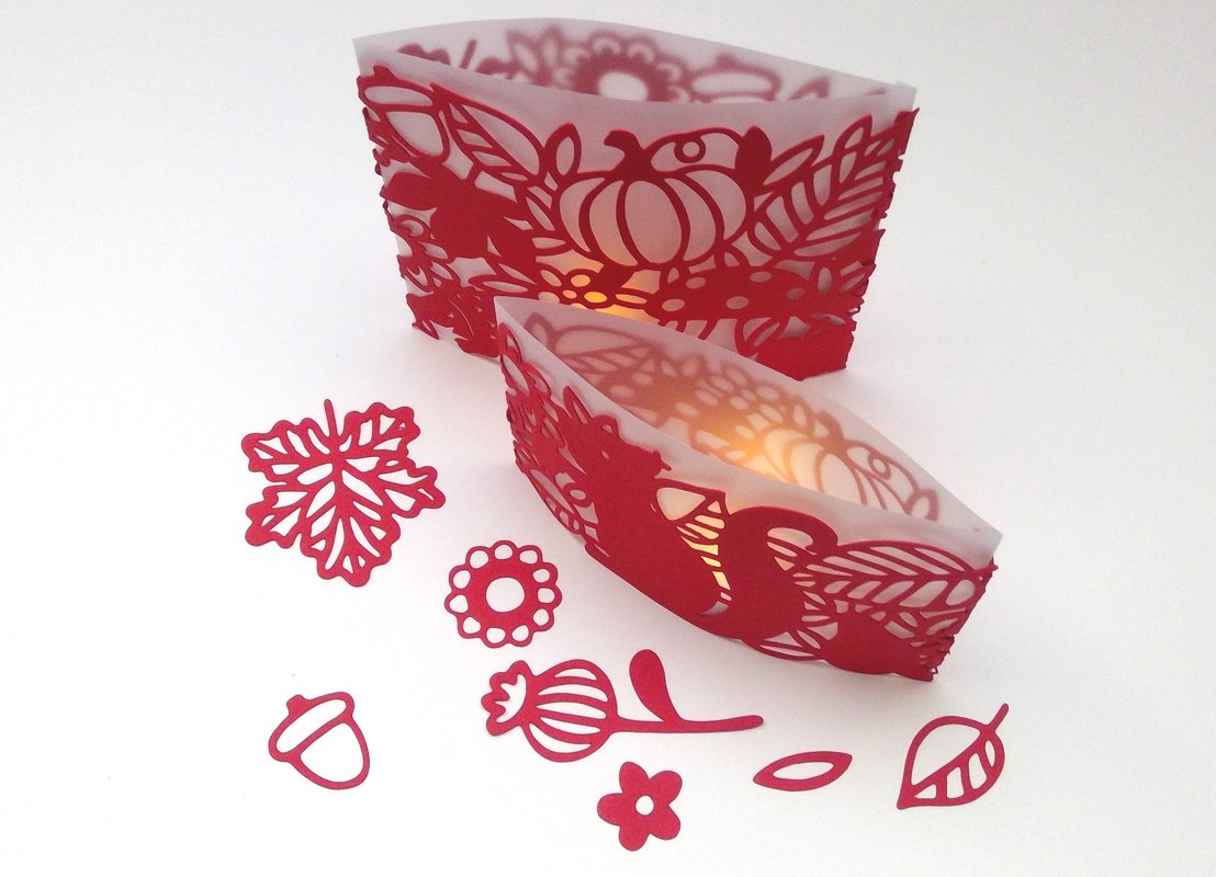 Plottvorlagen für zwei Windlichter mit herbstlichen, filigranen Mustern sowie separate rote Motive wie Blatt und Eichel auf weißem Hintergrund.