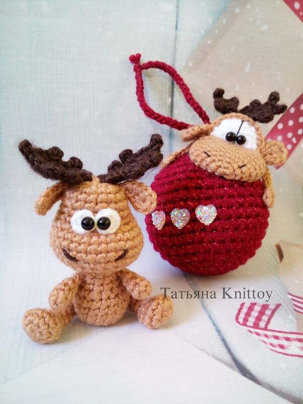 Zwei gehäkelte Rentier-Amigurumi, eins sitzend, eins an roter Häkelkugel mit Schlaufe