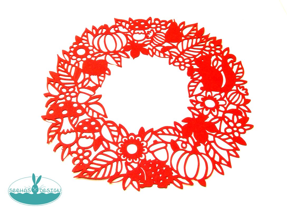 Roter Plott-Kranz mit ausgeschnittenen Blättern, Kürbissen, Pilzen und Eichhörnchen auf weißem Hintergrund.