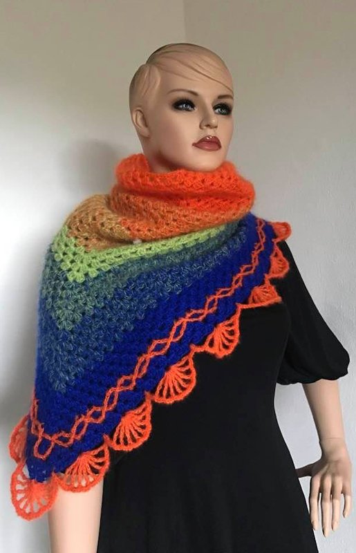 Mannequin trägt gehäkeltes dreieckiges Schultertuch in Orange, Grün und Blau mit Muschelkante