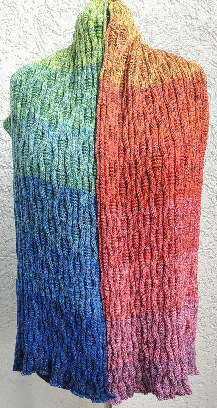 Gestrickter Schal mit Farbverlauf in Grün, Blau, Orange und Pink und vertikalem Wellenmuster