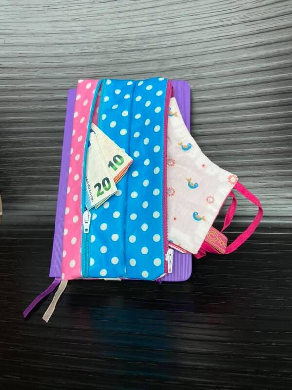 Genähte Geldbörse mit zwei Reißverschlüssen aus blau-weißen und rosa-weißen Punkten, gefaltete Geldscheine und kleine Stofftasche