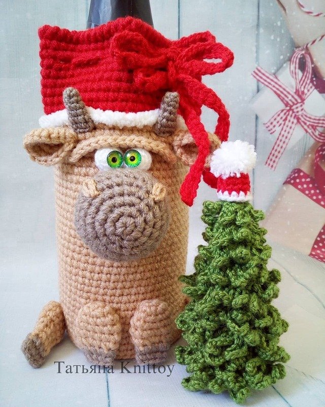 Gehäkelter Ochsen-Geschenkbeutel mit Zugband neben kleinem gehäkelten Tannenbaum
