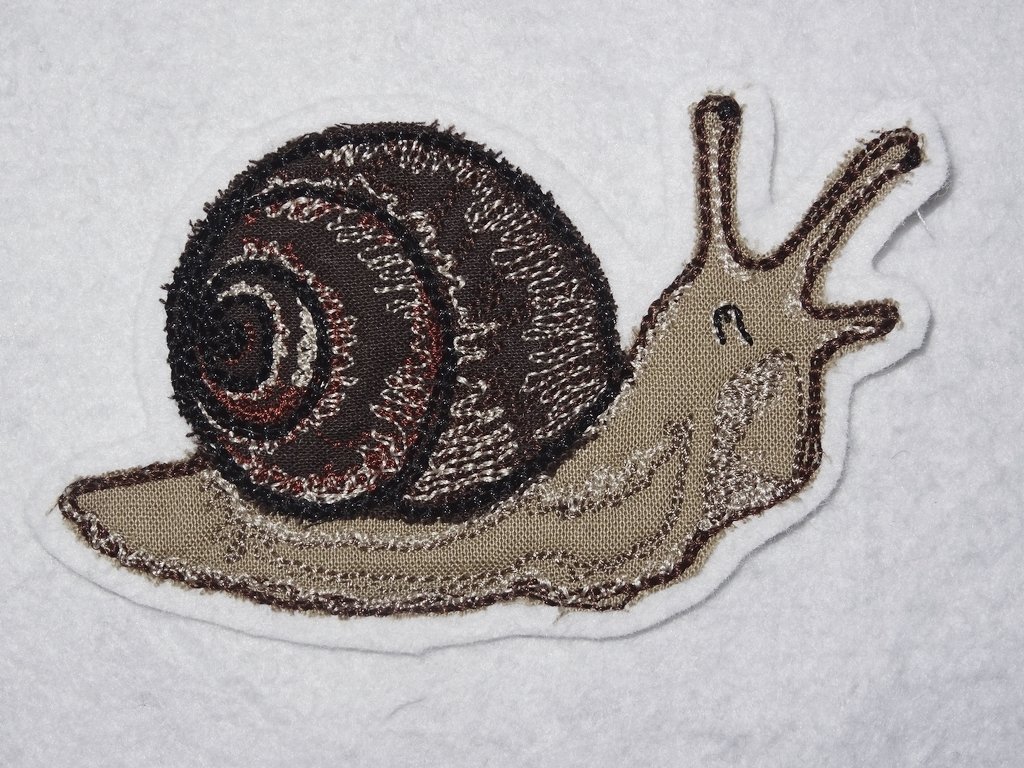 Gestickte Schnecke mit braunem Spiralschneckenhaus auf wei
ßem Stoff