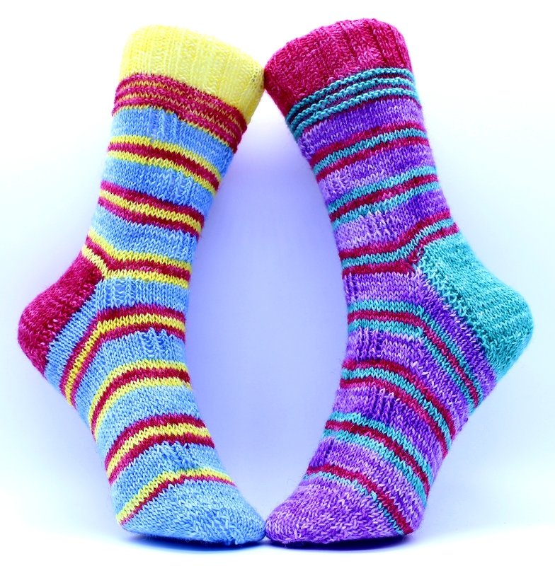 Zwei gestrickte Streifensocken mit deutlich sichtbaren Bündchen und Fersen