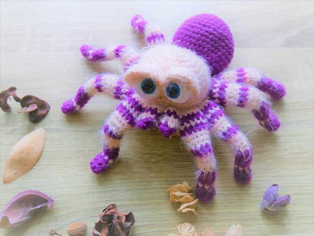 Lila-cremefarbene gehäkelte Amigurumi-Spinne mit großen Augen