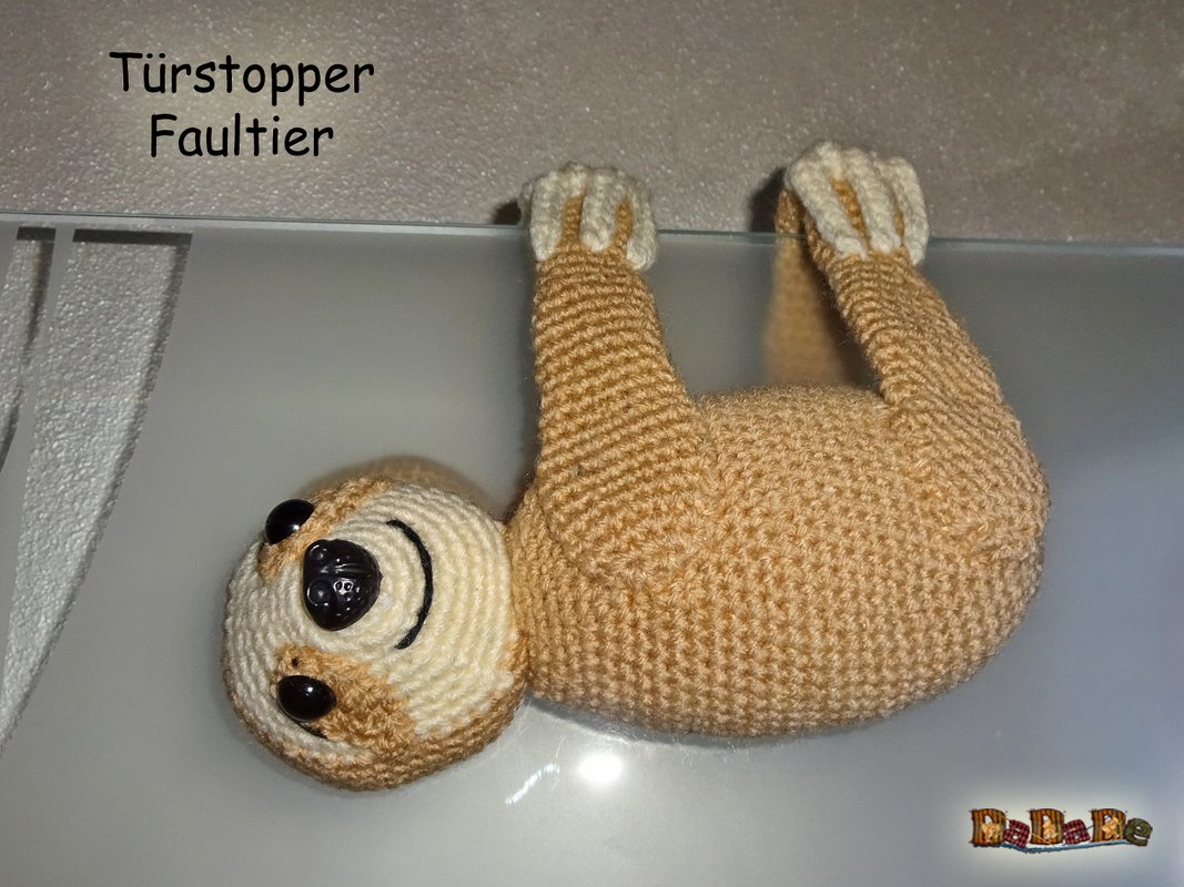 Gehäkelter Faultier-Türstopper in Beige und Creme, hängend