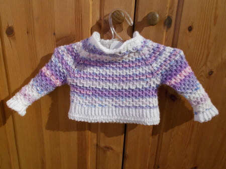 Gestrickter Baby-Pullover in Weiß mit lila-rosa Verlauf und Strukturmuster
